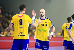 Piłkarze ręczni w żółtych koszulkach z numerami 9 i 50 świętują udany mecz vive.
