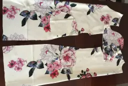 Kawałki materiału z kwiatowym wzorem, gotowe do szycia sukienki.