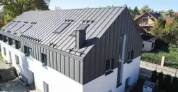 Nowoczesny dom z dachem z blachy trapezowej. Komin obrobiony blachą trapezową, idealnie komponuje się z całością.