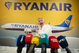 Michael O'Leary z Ryanair, pytany ile kosztuje przebukowanie biletu w Ryanair, wskazuje na samolot.