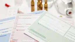 Mehrere medizinische Rezepte und Ampullen liegen auf einem weißen Tisch.