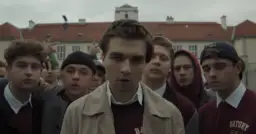 Grupa młodych ludzi, w tym chłopak w beżowej kurtce, zastanawia się, ile lat ma Mata.