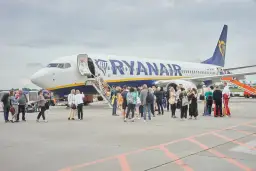 Pasażerowie wsiadają do samolotu Ryanair po schodkach.