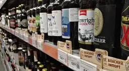 Butelki piwa na półce sklepowej. Zastanawiasz się, ile litrów wina można przywieźć do Polski? Przepisy celne mogą być skomplikowane, ale warto sprawdzić aktualne limity.