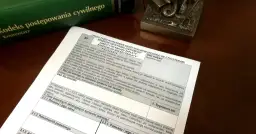 Zielona księga z tytułem "Kodeks postępowania cywilnego" i dokument z polami do wypełnienia.