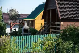 Ogródek z domkami, grillem i huśtawką. Czy myśliwy może strzelać w kierunku budynku? Nie, to niebezpieczne.