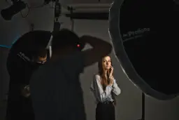 Sesja zdjęciowa w studiu. Fotograf z aparatem, modelka i oświetlenie. Inspiracja dla blogi o fotografii.
