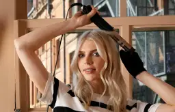 Blondynka tworzy loki prostownicą, pokazując jak zrobić loczki prostownicą.