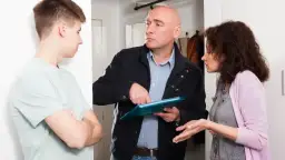 Dyskusja o tym, ile wynosi czynsz we wspólnocie mieszkaniowej. Mężczyzna w kurtce pokazuje dokumenty kobiecie i młodemu mężczyźnie.