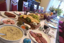 Uczta w gazdówce: bieszczadzkie smaki, kiełbasa, zupa, wędliny, winogrona i wielkanocne pisanki.