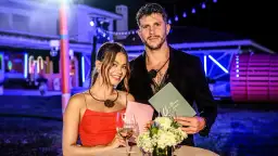 Para z Love Island, która wygrała, pozuje z uśmiechem. Ona w czerwonej sukience, on w czarnym garniturze.