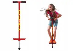 Dziewczynka z radością skacze na czerwonym pogo sticku.