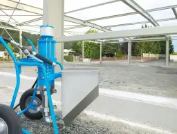 Niebieska pompa do betonu na placu budowy, gotowa do pracy przy konstrukcji stalowej.