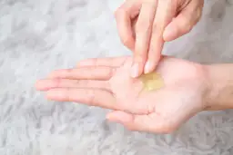 Delikatna aplikacja balsamu Szostakowskiego na dłoń, przygotowanie do nałożenia na ranę.