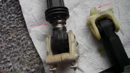 Zużyty amortyzator pralki Whirlpool z widocznymi uszkodzeniami i smarem.