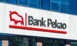 Logo Banku Pekao na białej fasadzie budynku, z niebieskimi oknami powyżej.