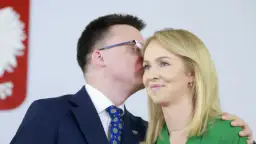 Szymon Hołownia szepcze coś do ucha swojej żonie Urszuli Brzezińskiej.