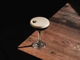 Espresso martini z gęstą, trwałą cremą, ozdobione ziarnem kawy. Idealny przepis na to, jak zrobić espresso martini, by uzyskać perfekcyjną piankę.