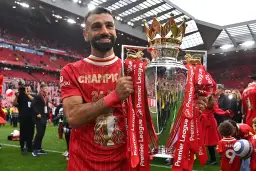 Piłkarz Liverpoolu, król strzelców Premier League, z pucharem mistrzowskim.