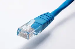 Niebieski kabel sieciowy Ethernet z wtyczką RJ45 na białym tle.
