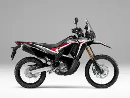 Czarny motocykl Honda CRF250 Rally z czerwonymi i białymi akcentami na szarym tle.