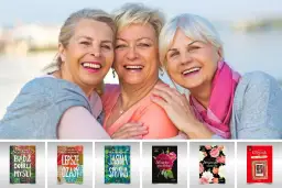 Trzy uśmiechnięte starsze panie, uosobienie tego, czym jest przyjaźń, na tle książek z inspirującymi tytułami.