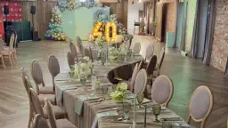 Elegancka sala bankietowa z nakrytymi stołami na 40 osób, balony i podświetlana liczba "40" sugerują, że to miejsce na udaną imprezę.
