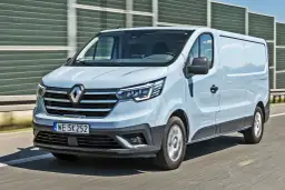 Jasnoszary Renault Trafic 2.0 na drodze, z widocznym przodem i bokiem pojazdu.