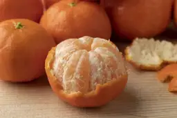 Kilka soczystych mandarynek, jedna częściowo obrana. Czy mandarynki są dobre na odchudzanie? Niska kaloryczność i witamina C mogą pomóc.