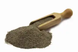 Stos mielonego pieprzu czarnego 1kg na drewnianej łyżce, gotowy do przyprawienia potraw.