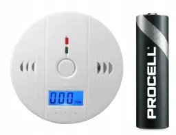 Biały czujnik czadu z wyświetlaczem pokazuje 000 PPM, obok bateria Procell.