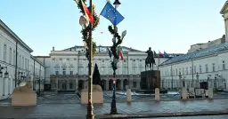 Pałac Prezydencki w Warszawie z pomnikiem konnym i flagami.