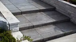 Nowoczesne schody zewnętrzne wyłożone płytami betonowymi. Idealne rozwiązanie, czym wyłożyć schody zewnętrzne, by były trwałe i estetyczne.