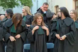 Grupa prawników w togach z zielonymi elementami.