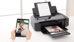 Drukarka atramentowa drukuje zdjęcie dziecka z tabletu. Wybór odpowiedni jaki papier fotograficzny do drukarki atramentowej zapewni najlepszą jakość.