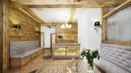 Wnętrze spa z drewnianymi elementami, kanapami, ladą z kosmetykami i bukietem róż.