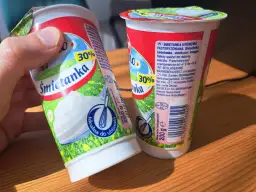 Dwie śmietanki 30% z karagenem, jedna w dłoni, gotowe do ubijania. Idealne do deserów.