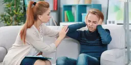 Terapeutaka wspierająca nastolatka z depresją, który zakrywa uszy.