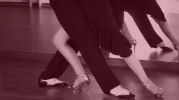 Para tańczy w rytm muzyki, wykonując eleganckie tańce standardowe. Ich ruchy są płynne i pełne gracji.