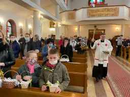 Kiedy jest czuwanie w kościele, wierni z koszyczkami czekają na błogosławieństwo. Kapłan święci pokarmy.