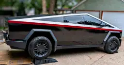 Czarny Tesla Cybertruck z białym i czerwonym pasem, jak wygląda samochód Tesla.