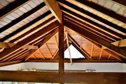 Widok na drewniany strop z widocznymi belkami, idealny do rozważenia, jakie belki na strop drewniany 5m będą najlepsze.