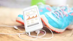 Darmowa aplikacja do biegania pokazuje statystyki treningu: 5 mil, 904 kalorie, 41:53 czasu. Obok leżą buty do biegania.