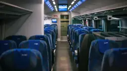 Wnętrze pociągu Intercity z rzędami niebieskich siedzeń. Brak widocznych oznak palarni.