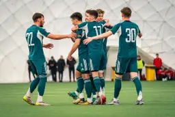 Legia Warszawa zawodnicy w zielonych strojach świętują na boisku.