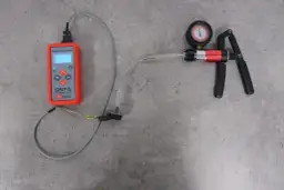Tester QST-5 i próżniomierz z pompką ręczną pokazują, jak działa map sensor, symulując zmiany ciśnienia.