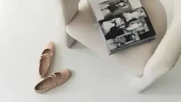 Beżowe baleriny Ryłko z paskiem, idealne, by dowiedzieć się, jak zmiękczyć buty na pięcie. Obok otwarta księga.