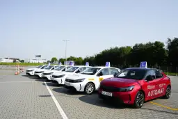 Rząd białych i czerwony samochód nauki jazdy na placu manewrowym. Zastanawiasz się, ile kosztuje prawo jazdy w Polsce?