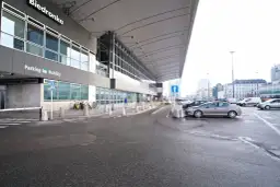 Parking przy Dworcu Centralnym w Warszawie, z widocznym budynkiem Biedronki i samochodami.