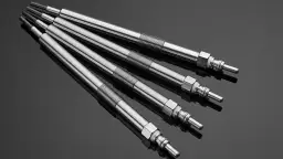 Cztery metalowe świece żarowe leżące na błyszczącej powierzchni.